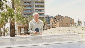 Man playing table tennis outdoors - Powered by Shutterstock - Get 15% off with code: PIKWIZARD15