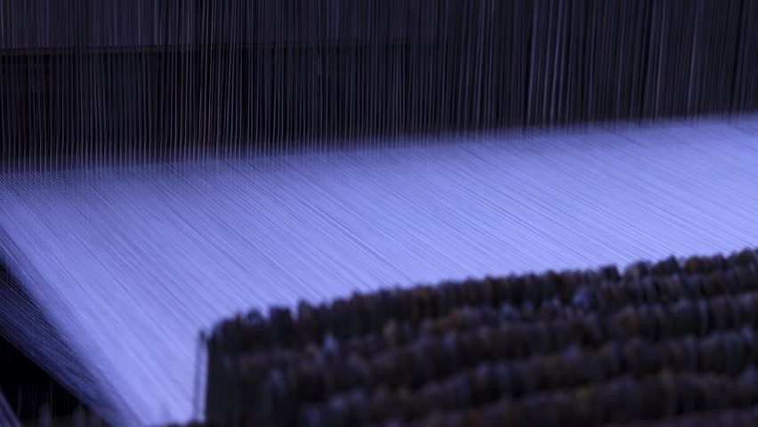 Rotating knitting machine with multiple threads and needles moving rhythmically up and down. Close-up in a textile factory. Precision mechanical motion.
Yarn factory
