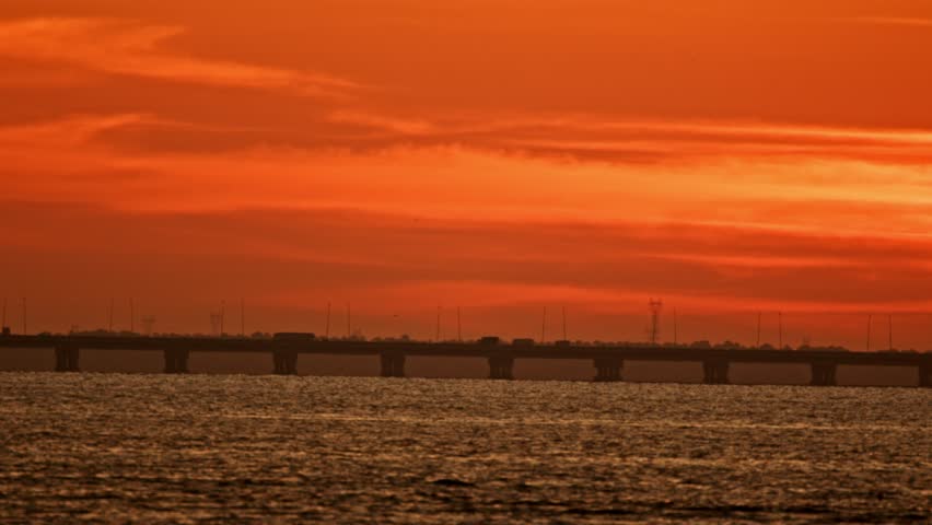 Majestic orange sunset over bridge and water