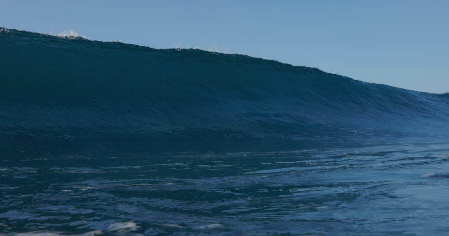 Breaking surfing wave. Crashing barrel blue wave in sunny day