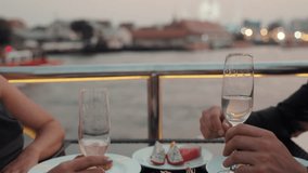Romantic partners hands clink glasses of expensive wine on dinner riding luxury yacht closeup. Young couple celebrates anniversary sailing modern ship on sea journey in evening - Powered by Shutterstock - Get 15% off with code: PIKWIZARD15