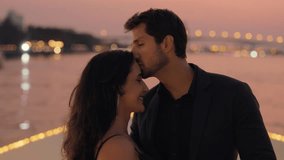 Portrait of passionate Latin woman and man kiss embracing sailing on yacht at twilight. Romantic atmosphere of pretty Hispanic couple date on sea journey by motorboat in Thailand - Powered by Shutterstock - Get 15% off with code: PIKWIZARD15