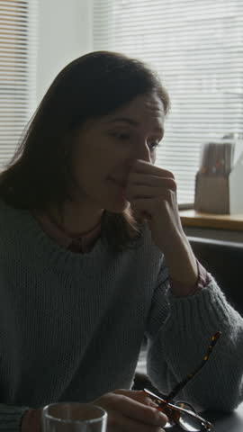 Vertical waist up shot of young Caucasian woman looking upset as she sharing her feelings during individual therapy session