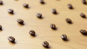 The focus moves to the coffee beans lying on the wooden table, showing their texture and variety, as well as the depth of the frame and the texture of the table. - Powered by Shutterstock - Get 15% off with code: PIKWIZARD15
