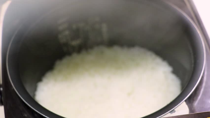 White rice cooked in a rice cooker, (translation) Japanese words written inside the bowl mean white rice and germinated brown rice