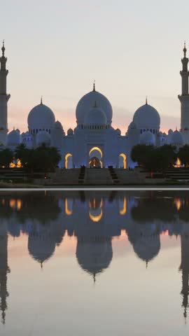 Timelapse illuminated stunning Sheikh Zayed Grand Mosque at sunset, Abu Dhabi, UAE. Tourist sightseeing famous grand mosque attraction in United arab emirates. 4k high quality colorful day to night
