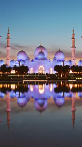 Timelapse illuminated stunning Sheikh Zayed Grand Mosque at sunset, Abu Dhabi, UAE. Tourist sightseeing famous grand mosque attraction in United arab emirates. 4k high quality colorful day to night