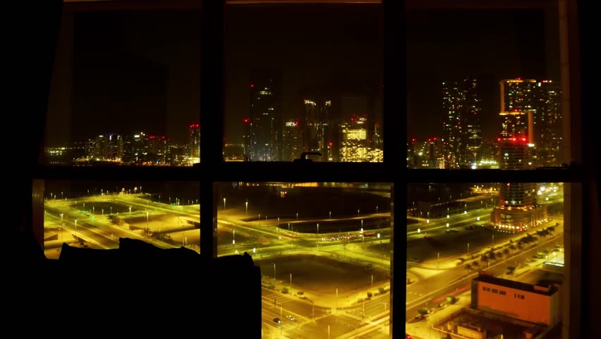 High-Rise new building Bedroom Window View Abu Dhabi Cityscape with Traffic Below at night. Safety business promo banner vertical copy background cityscape modern apartments mortgage rentals concept