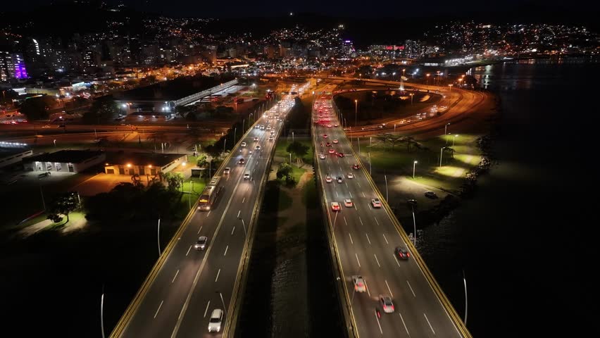 Night Skyline In Florianopolis Santa Catarina Brazil. Aerial View Of Landmark Bridge Showcasing Its Intricate Design . Building Clouds Sky Downtown Cityscape. Night Outdoors Panning Wide.