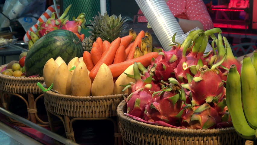 Exotic fruit stall in Phuket, Thailand / vendor selling fresh fruit juice behind a market stall