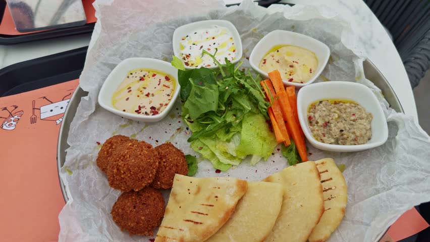 Mediterranean Food With Pita And Falafel. Arabian Cuisine. Traditional Middle Eastern Food. Fried Falafel Made From Chickpeas. Delicious Mediterranean spread falafel, dips, vegetables and flatbread 