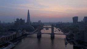 Experience breathtaking aerial footage showcasing the iconic Tower Bridge alongside the stunning London skyline at twilight, magnificently reflected in the tranquil waters of the serene River Thames - Powered by Shutterstock - Get 15% off with code: PIKWIZARD15