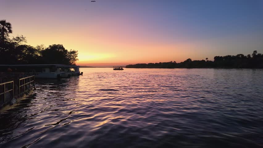 Sunset River In Zambezi River Victoria Falls Zimbabwe. Aerial View Of A River Surrounded By Lush Green Tropical Rainforest. Landscape Dramatic Sky Waterfall Tropical. Landscape Powerful Flow.