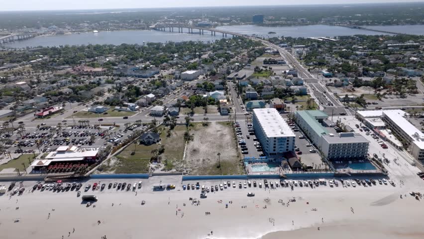 Daytona Beach, Florida with vehicles and people on the beach with drone video moving left to right.