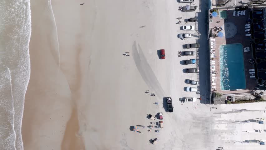 Daytona Beach, Florida with waves from Atlantic Ocean and drone video overhead, looking down and moving up.