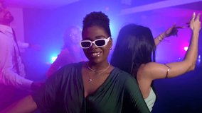 Young women dancing and enjoying energetic nightclub atmosphere, moving to electronic beats with friends amid colorful lights and vibrant celebration - Powered by Shutterstock - Get 15% off with code: PIKWIZARD15