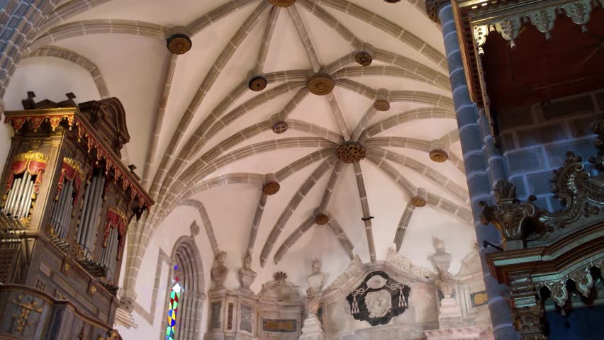Golden pipe organ and vaulted ceiling in richly decorated historic church interior