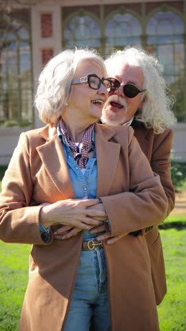 A charming elderly couple joyfully enjoying each other's company while smiling and pointing, radiating love and connection in a delightful moment of togetherness that captures their unique bond and