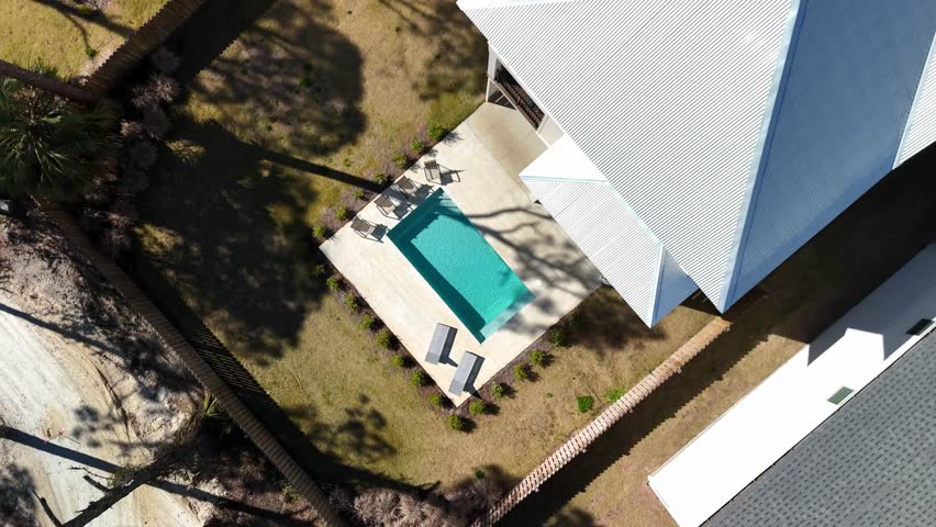Top-down spiral drone movement from the suburban houses with small backyards and private pools at Panama City Beach, Florida, USA