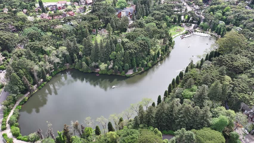 Black Lake In Gramado Rio Grande Do Sul Brazil. Tropical River With A Scenic Forest Trees Viewed From Above. Town Clouds Sky Backgrounds Urban. Town Outdoor Panning Wide. Gramado Rio Grande do Sul.