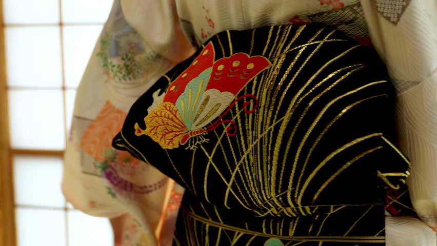 A Woman Putting on a Traditional Japanese Kimono for a Woman in an Old Traditional Japanese House