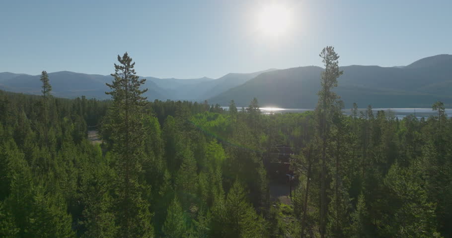 Drone shot of the mountains through the trees at sunrise in Grand Lake, Colorado