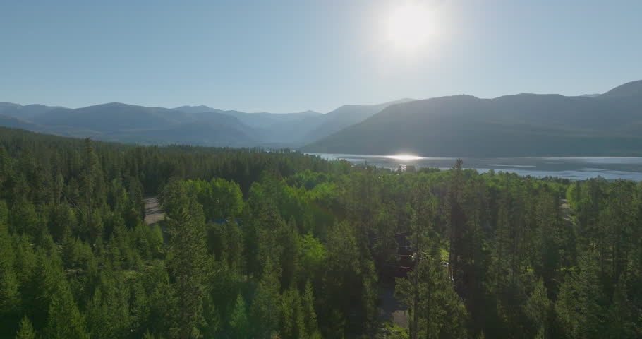 Drone shot of the mountains through the trees at sunrise in Grand Lake, Colorado