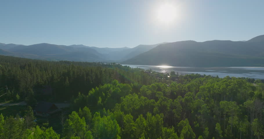 Drone shot of the mountains through the trees at sunrise in Grand Lake, Colorado