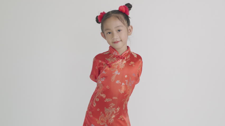 Happy Chinese New Year Asian girl in traditional red cheongsam qipao dress making a congratulatory gesture. Perfect for festive themes, isolated on a white background.