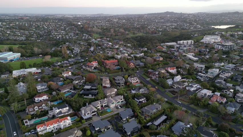 Drone shot of luxury homes in Kohimarama, Auckland, bathed in evening light with panoramic view, New Zealand