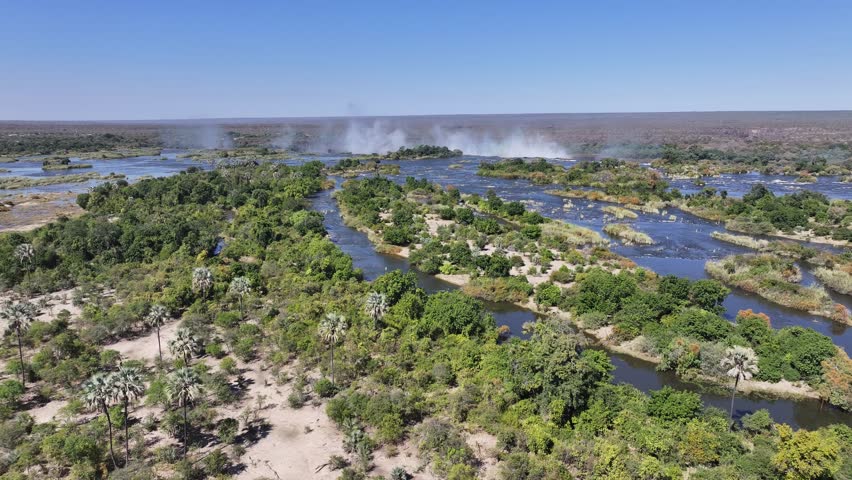Zambezi River In Victoria Falls Matabeleland North Zimbabwe. Aerial View Of A River Surrounded By Lush Green Tropical Rainforest. Landscape Sky Waterfall Tropical. Outside Waterfall Panorama.