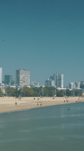 Mumbai, India. Pigeon Fly In Slow Motion Above Around Back Bay Coast Of Mumbai City. City Skyline From Marine Drive. Skyscrapers And Saifee Hospital. Clear Blue Sky. Family Holiday Concept. People