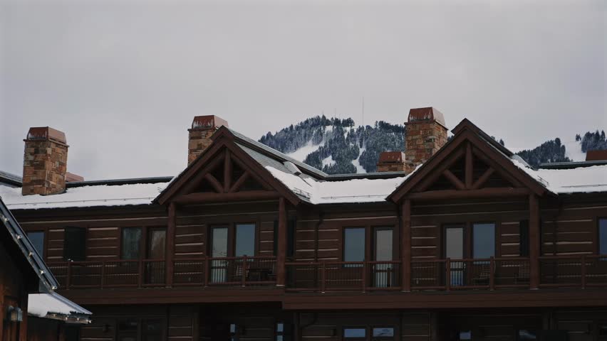 Rustic Chalets with Snowy Peaks Behind in Wyoming