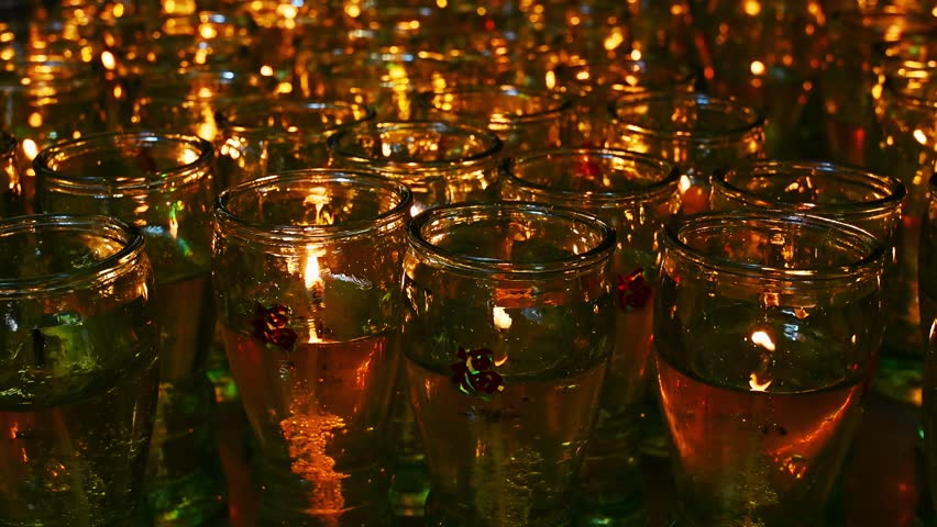 burning candles in glasses in a Buddhist temple. The Symbol of Faith