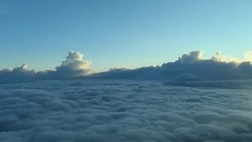 an aerial view of a stormy cloudscape as seen from a jet airplane cockpit while flying at sunset over a layer of clouds and with threatening storm clouds ahead - Powered by Shutterstock - Get 15% off with code: PIKWIZARD15