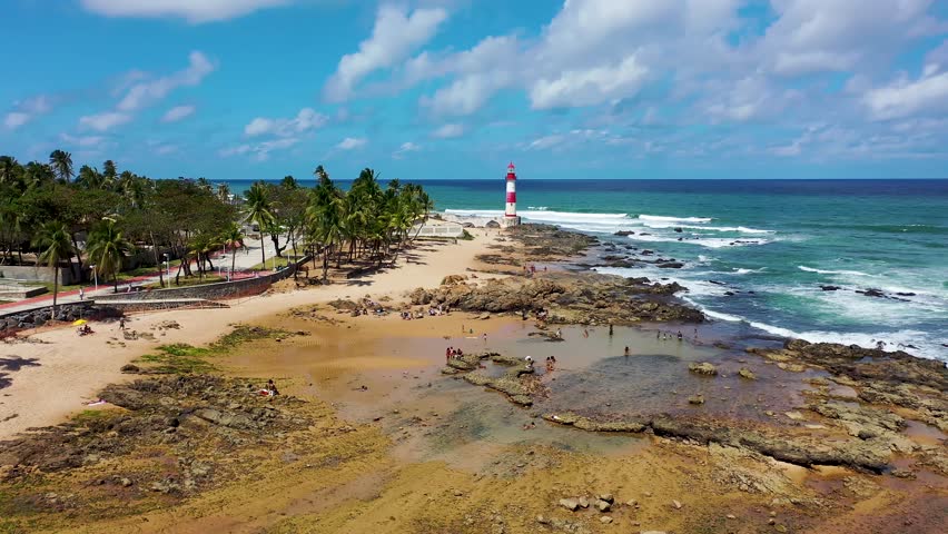 Itapua Lighthouse In Salvador Bahia Brazil. Aerial View Of A Landmark Tall Lighthouse In A Coast Beach. Shore Horizon Beach Sea. Seaside Panning Wide. Salvador Bahia.