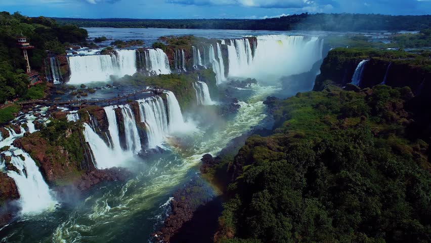 Iguazu Falls In Foz Do Iguacu Parana Brazil. Cliffside Surrounded By Lush Green Forest Viewed From Above. Landscape Dramatic Sky Waterfall Tropical. Landscape Mountain Panoramic View.