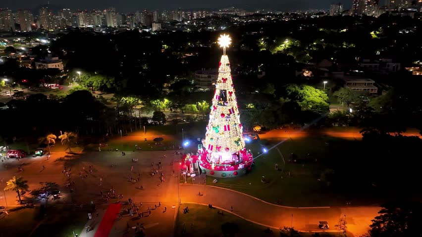 Christmas Tree In Candido Portinari Park Sao Paulo Brazil. Aerial View Of Christimas Tree And Ornaments To Happy Holidays. Building Clouds Sky Downtown Cityscape. Night Outdoors Panning Wide.