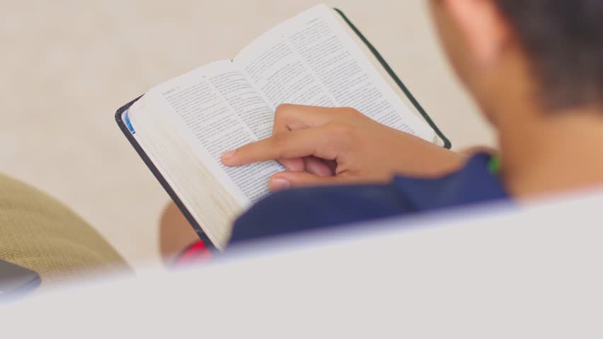 A man is pointing at a page in a book