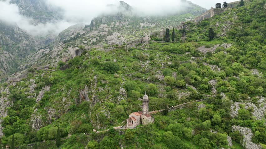 Aerial View of Mountaintop Church in Montenegro Above Kotor’s Foggy Green Forests