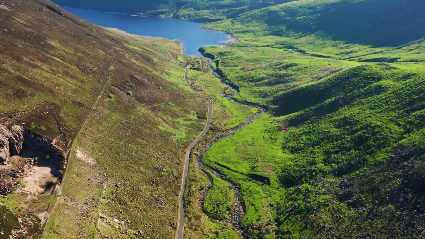 Aerial Descent Over Silent Valley With Curved River and Grassy Hills on a Bright Summer Day