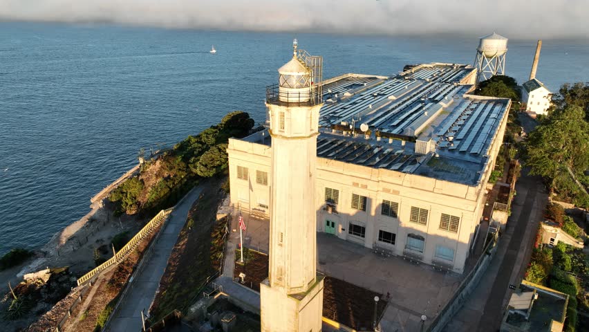 Alcatraz Island In San Francisco California United States. Lighthouse Standing Tall On Beach With Ocean Waves Crashing. Business Sky Clouds Downtown Cityscape. Backgrounds Panoramic.