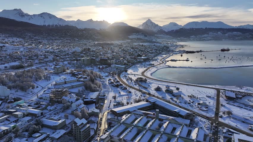 Ushuaia Skyline In Ushuaia Tierra Del Fuego Argentina. Capturing The Hustle And Bustle Of A Vibrant City From Above. Sunset Snowy Illumination Patagonia Landscape Frozen Background.