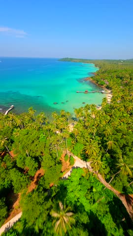 Cinematic FPV drone flight over tropical paradise beach with crystal-clear turquoise sea and palm trees on Koh Kood island in Thailand