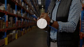 Warehouse supervisor writing on clipboard, securing helmet and generating digital icon network. Industrial, automation, technology, inventory, logistics, connectivity, infrastructure - Powered by Shutterstock - Get 15% off with code: PIKWIZARD15