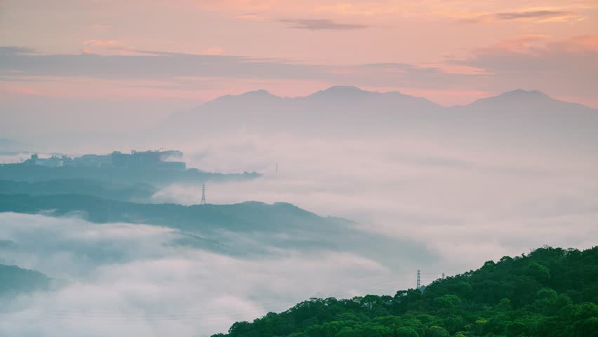 A breathtaking twilight scene unfolds over Datun Mountain in New Taipei City, Taiwan, showcasing a sky painted in beautiful shades of pink and orange.