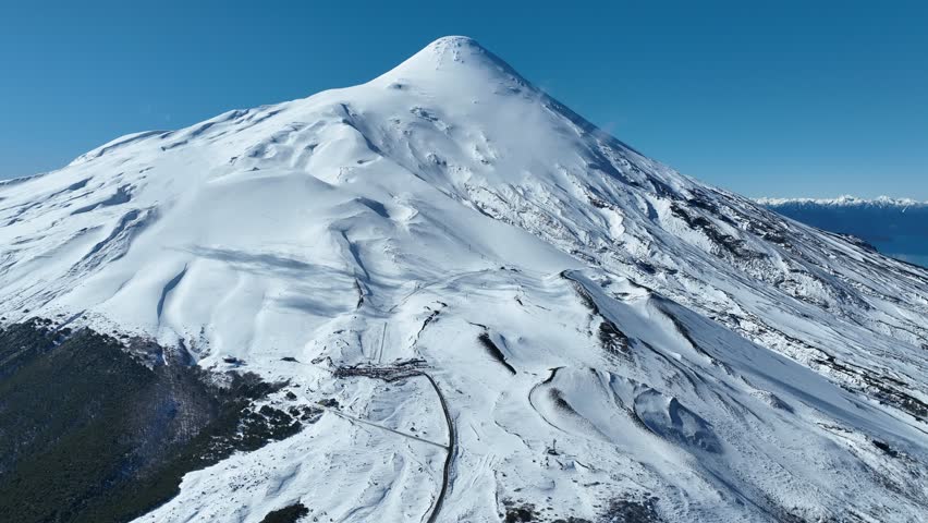 Osorno Vulcan In Petrohue Los Lagos Chile. Snow-Capped Volcano Releasing Plumes Of Smoke Into Blue Sky. Snowing Day Lake Glacial Blizzard. Glacial. Petrohue Los Lagos.