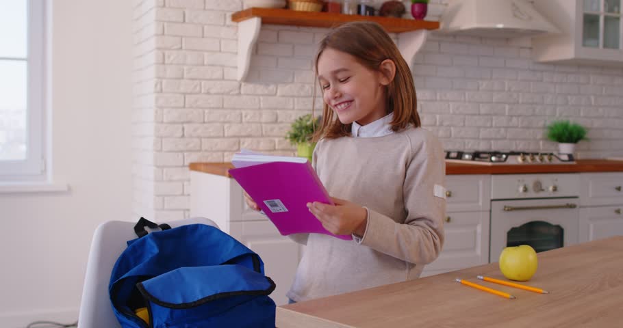Schoolboy getting ready for school, packing his backpack, preparing for studying after summer vacations, glad to meet his classmate soon. Children, studying and back to school concept