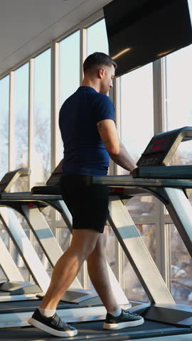 Man running on treadmill at modern gym