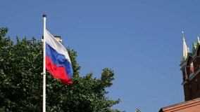 Russian flag waving near the Kremlin tower in Moscow on a sunny day. A symbol of national pride and history, showcasing traditional architecture and cultural heritage - Powered by Shutterstock - Get 15% off with code: PIKWIZARD15